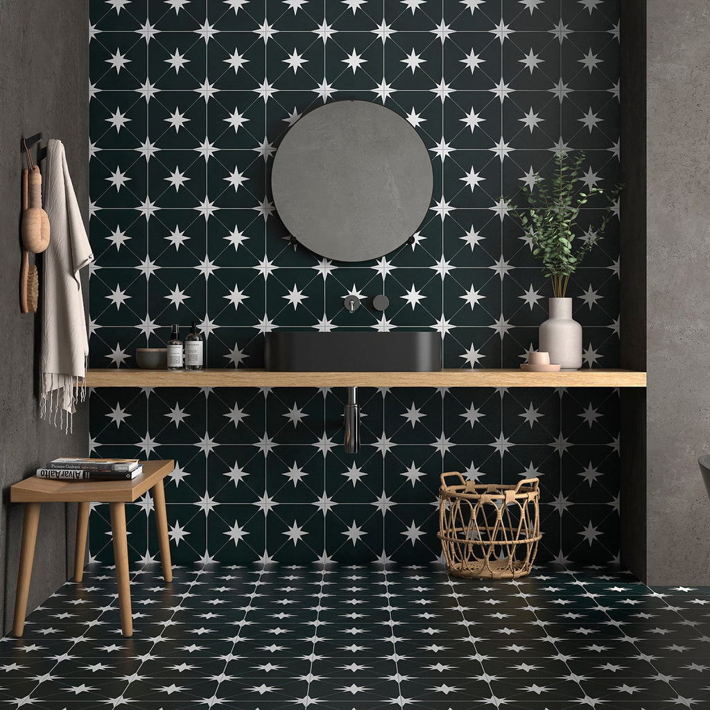 Modern bathroom with black and white patterned tiles, wooden vanity, and freestanding bathtub.