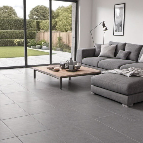 Modern living room with gray sectional sofa, coffee table, and large windows.